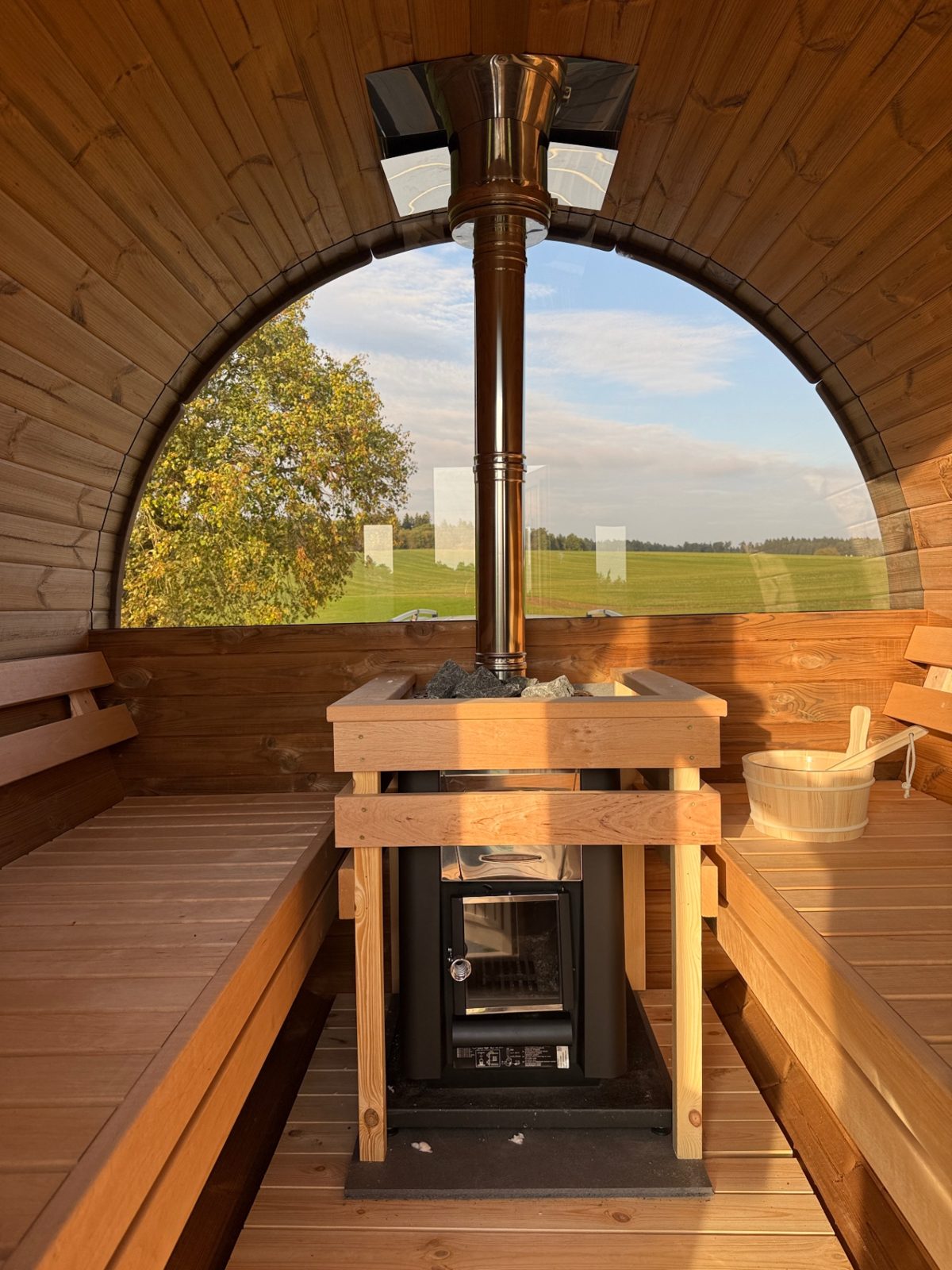 Innenraum der Miet-Fasssauna mit Holzofen